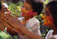 A child smears powder paint over her mother's face