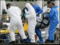 ماموران نجات درحال حمل جسد يکی از قربانيان سقوط هواپيما