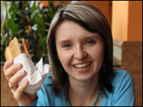 手拿汉堡包的一位女性