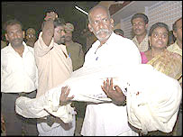 दुर्घटना में मारे गए एक बच्चे का शव ले जाते उनके परिजन