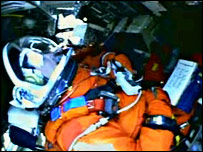 يک فضانورد در جايگاه خود در شاتل مستقر شده است