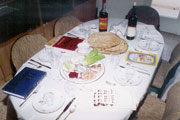 Table with seder meal and Haggadah by every place