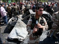 Lính Iraq đứng trước chiếc xe hơi bị đánh bom