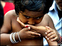 Refugiada recebe comida das mãos de sua mãe em Port Blair, sudeste da Índia