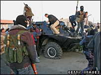 شبه نظاميان حماس در حال گرفتن سلاح از يک خودروی زرهی 