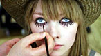 Girl having eye make-up applied