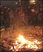 Pupils standing around a bonfire
