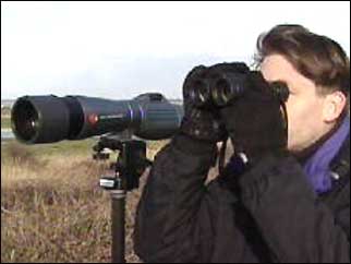 Chris Packham looking through binoculars