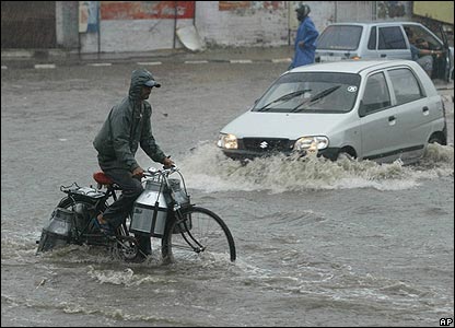 Đạp xe trong nước lũ ở Jammu.