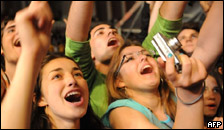Fans shouting and waving to a music group