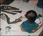 young girl drawing with paint