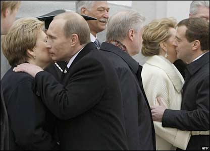 Ông Vladmir Putin (trái) chào bà Naina, phu nhân cố tổng thống Boris Yeltsin và ông Dmitry Medvedev ôm hôn đệ nhất phu nhân Svetlana 