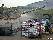 Một nông dân đi qua xe tăng Israel ở Lebanon