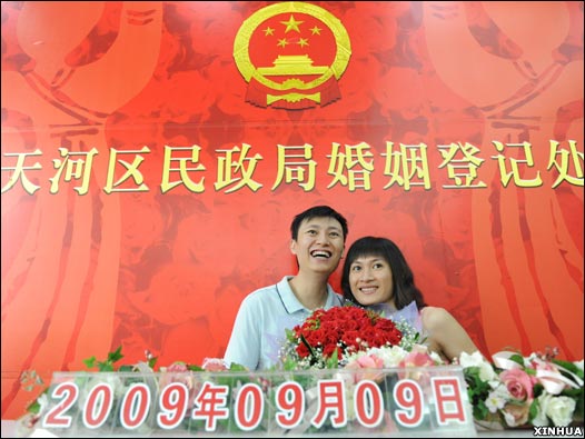 广州天河区婚姻登记处外一对新人合影留念(新华社图片9/9/2009)
