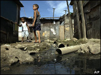 Menino ao lado de esgoto aberto em favela do Rio