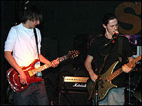 Two members of Newstate playing guitars