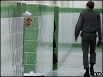 Một nữ tù nhìn ra cửa khi người coi tù đi qua