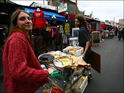 两个年轻人推着自制的食物在跳蚤市场内叫卖，生意不错。