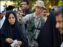 Soldado dos EUA supervisiona fila de iraquianos em busca de assistência