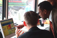 Mr Grahame Davies uwch-gynhyrchydd BBC Cymru'r Byd yn dangos BBC Vocab Saesneg Somalieg ar fws BBC Cymru yn Butetown