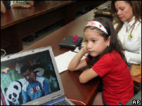 Ao lado da mãe, menina assiste a vídeo com imagens do pai seqüestrado na Colômbia