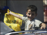 Criança sorrindo exibe bandeira