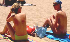 Two female sunbathers on a beach