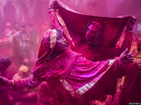 Men covered in pink powder during the festival of Lath mar Holi in Northern India