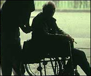 Carer with elderly man in wheelchair