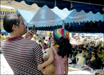 Hai bố con chụp ảnh trong khi lắng nghe lãnh đạo phát biểu