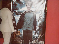 Mulher em frente a um pôster do Harry Potter