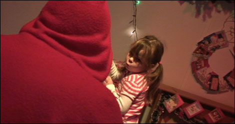 Santa greets a child after the sleigh ride