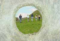 'Llech Ronw' a'r plant ar y daith yn y cefndir