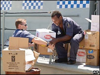 Militar australiano ajuda policial para descarregar remédios e alimentos