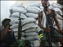 Rebeldes armados com mercadoria saqueada em Gonaives, no Haiti