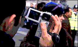 Man filming a woman with a video camera