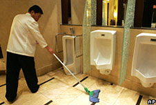 A Chinese worker cleans up a toilet