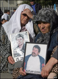 Albanesas seguram retratos de parentes desaparecidos desde a guerra em 1999