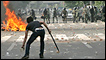Supporters of opposition leader Mir Hossien Mousavi set fire to a barricade as they hurl stones at riot police during a protest in Tehran on Saturday June, 20, 2009