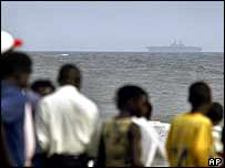 Liberianos observam navio americano na costa de Monróvia