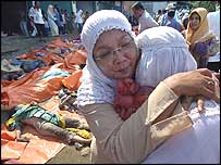 Mulher consola pessoas em Banda Aceh, na Indonésia