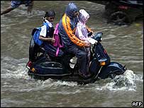 موتور سوار اهل بمبئی راهش را از ميان سيل باز می کند