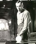 Worker rolling and shaping glass