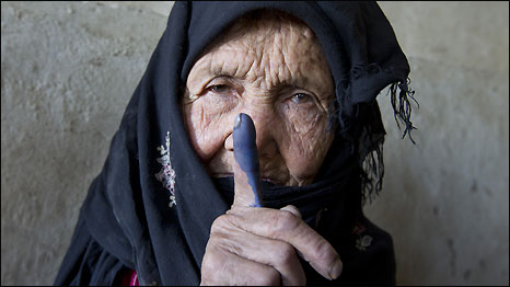 An elderly woman shows off her inked finger after she cast her vote in Afghanistan's elections in September 2010.
