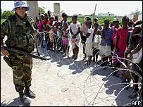 Soldado da ONU em ponto de distribuição de alimentos
