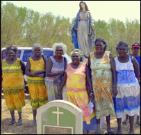 Mulheres tiwi posam para foto em frente a uma cova nas ilhas Tiwi