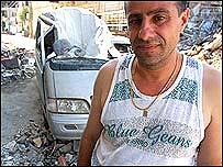 Morador Ali Taher, em frente ao seu carro destruído