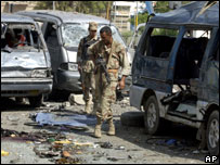 Soldados iraquianos examinam carros danificados por explosão em Bagdá