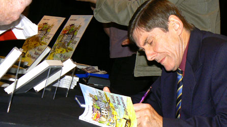 Harri Parri yn arwyddo copi o un o'i lyfrau