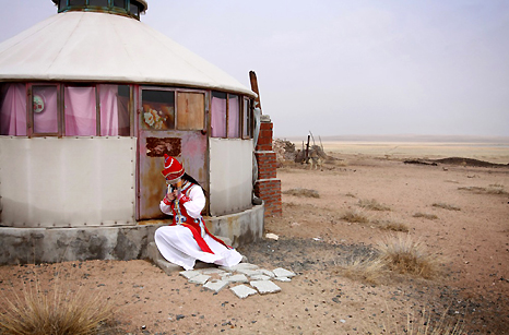 A tourist tries on traditional clothes on the Inner Mongolian grasslands, which have deteriorated as a result of overgrazing in recent years. 2009